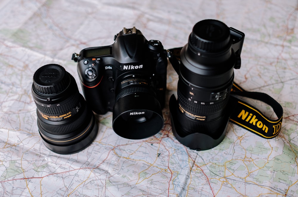 two black Nikon DSLR cmeras and lens
