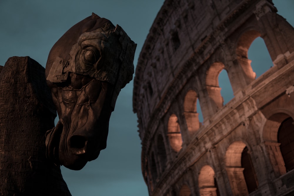 sculpture de tête de cheval en bois brun à côté du Colisée