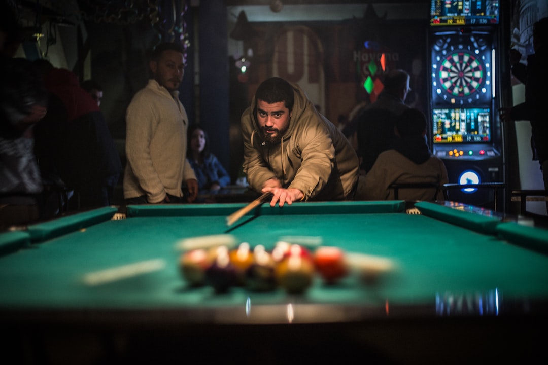 man in brown jacket playing billiard