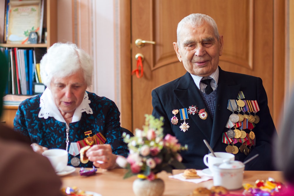 man and woman drinking coffee in front of wooden table