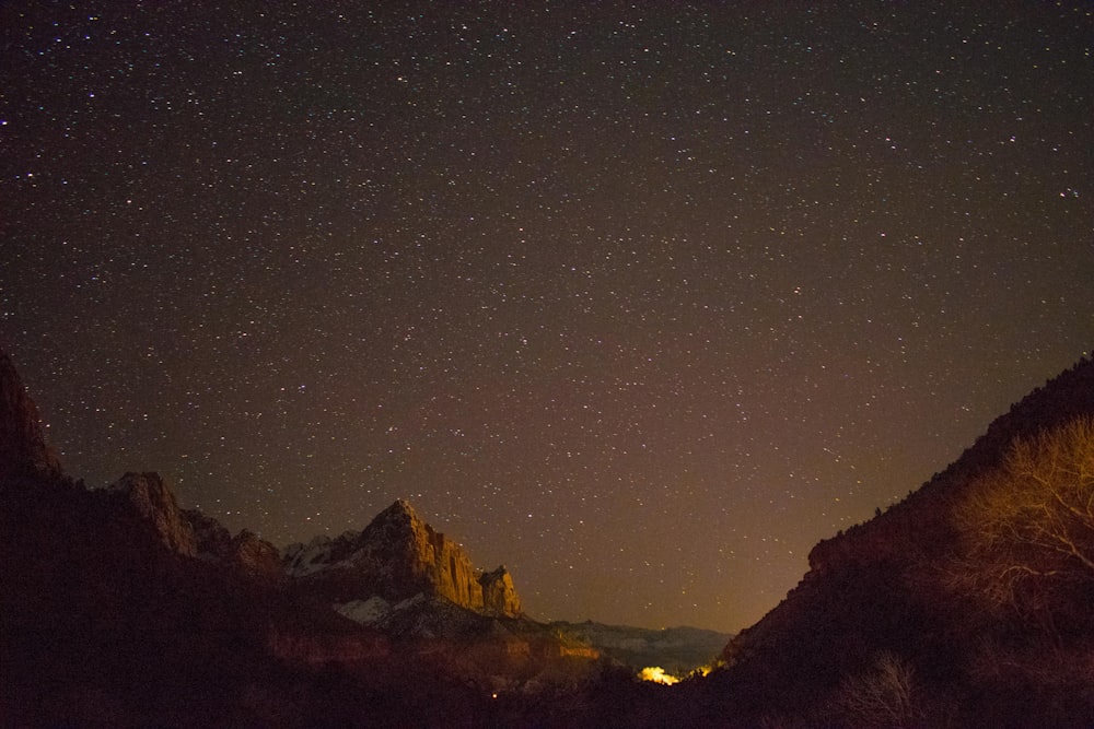 brown rock formation under starry night