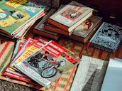A stack of Retrofuel magazines resting on a wooden table with a racing helmet beside them.