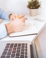 person writing on white notebook