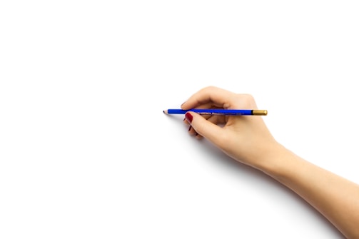 A friendly hand reaching out with a pen ready to write on a contact form.