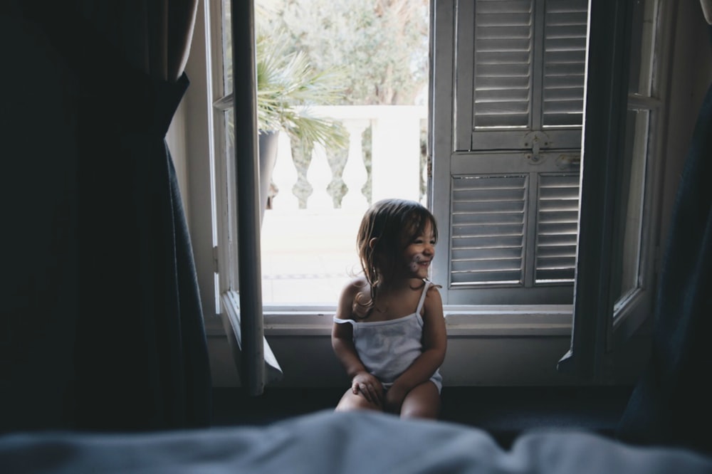 chica sentada junto a la ventana durante el día