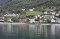 A peaceful coastal village scene with colorful houses nestled among lush tropical greenery.