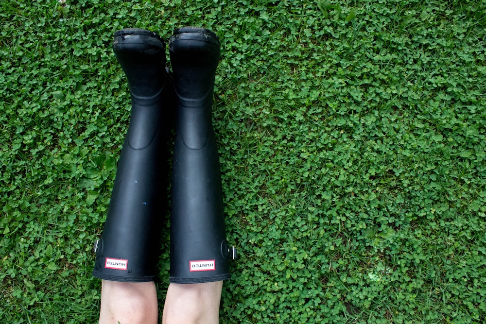 person wearing pair of black rain boots