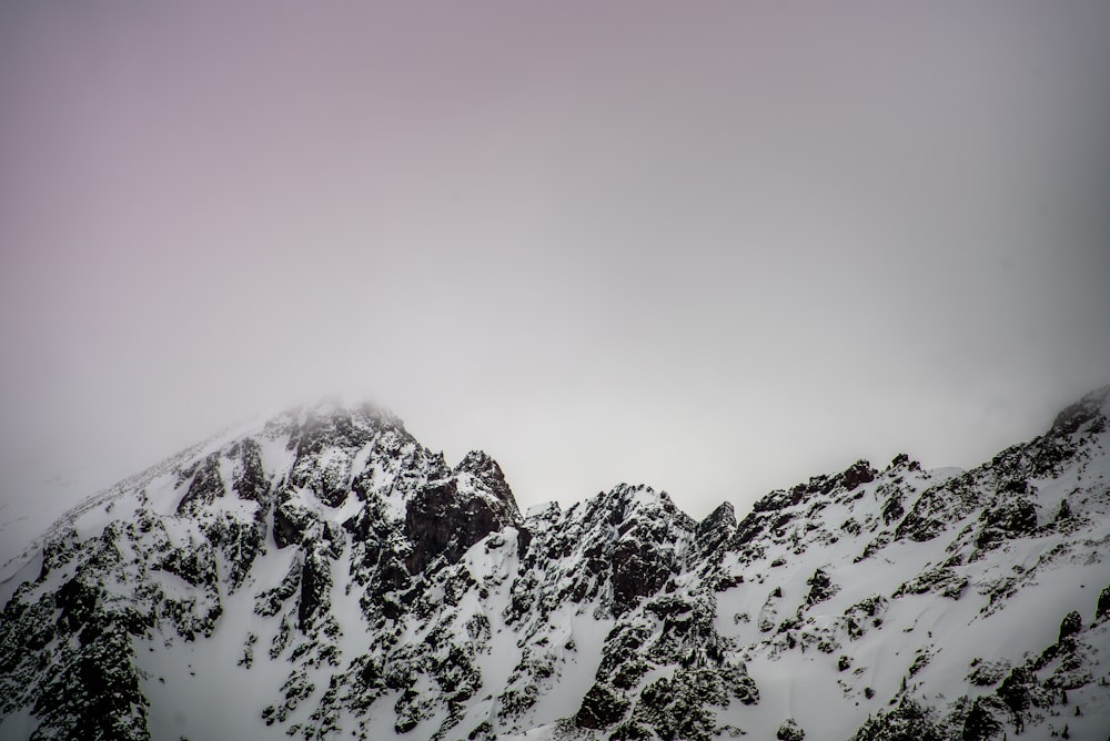 snow covered mountain under gray cloudy sky