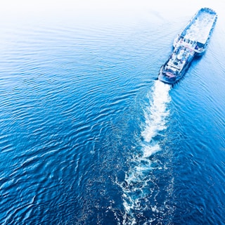 A large cargo ship navigating through calm blue waters.
