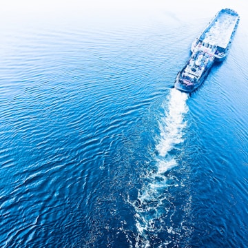 Aerial view of a modern cargo ship navigating through calm waters.