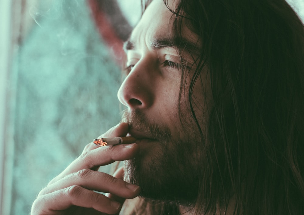 homem fumando cigarro vermelho