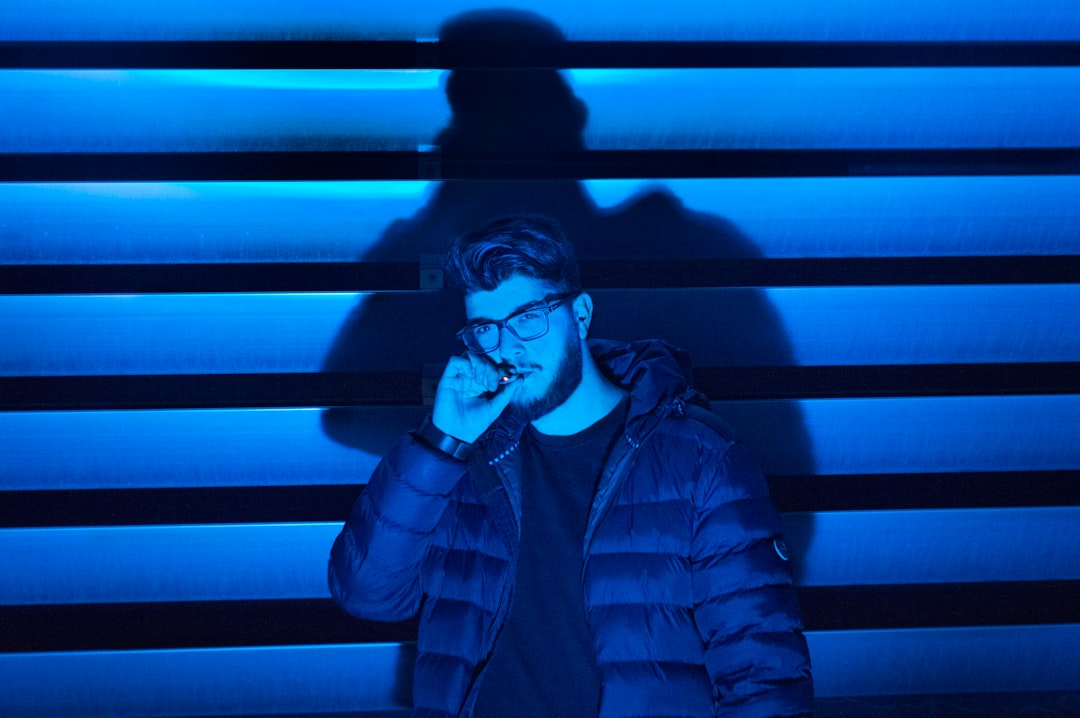 man smoking standing near wall