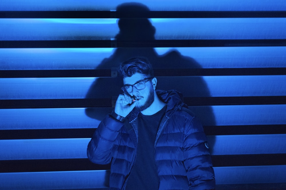 man smoking standing near wall