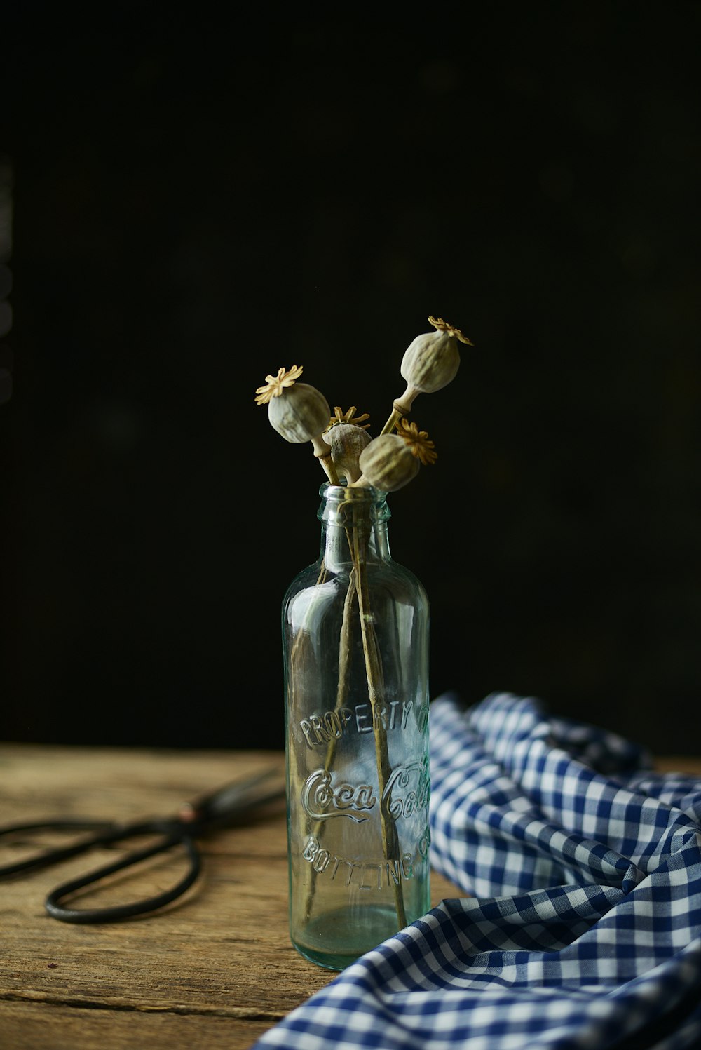 Klarglasflasche mit weißen Blumen auf dem Tisch