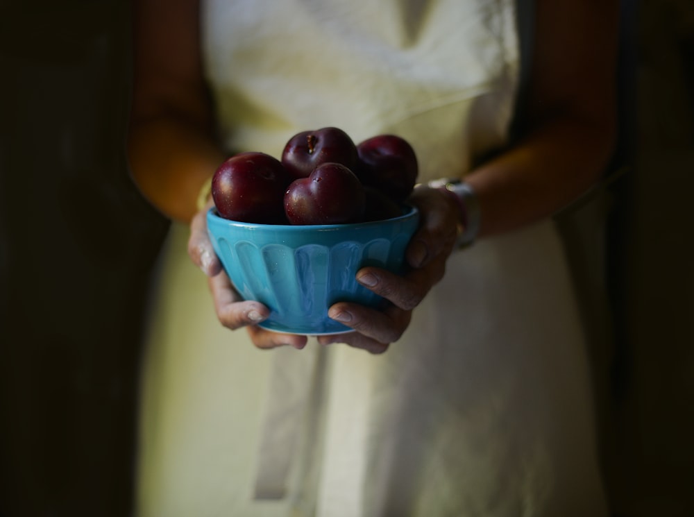 woman holding bowl filled with apples
