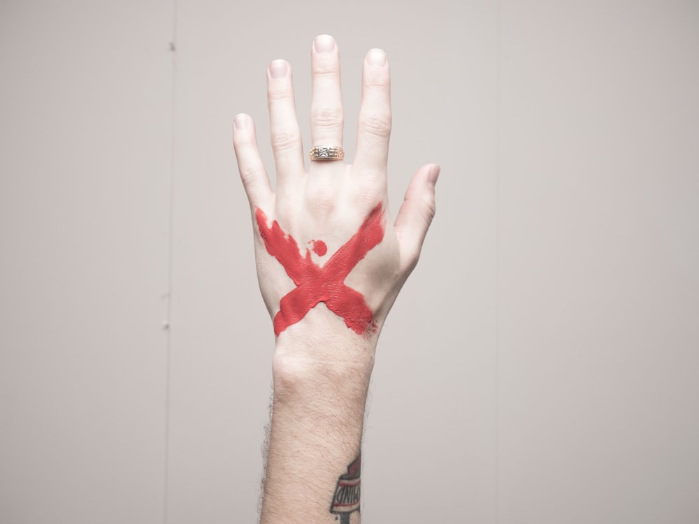 Mano humana izquierda con marca X