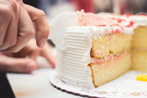 Close-up of a beautifully decorated vanilla cake with subtle gold accents on a white plate.