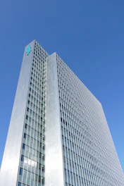 Minimalist silver and emerald icon of a commercial building representing corporate credit consultancy.