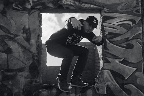 Model posing casually in a sunlit loft wearing casual streetwear.