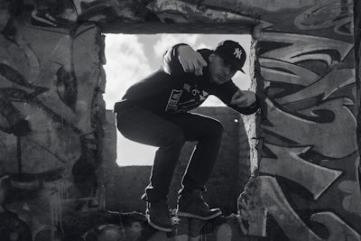 Model wearing a custom exa cap against a gritty urban graffiti wall.