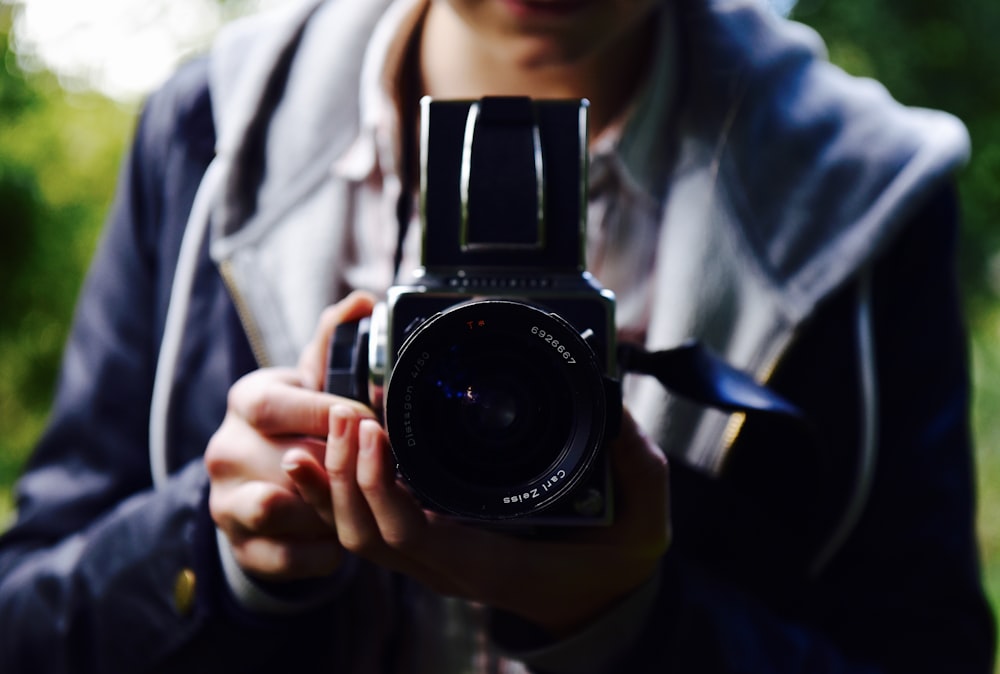 person holding black DSLR camera