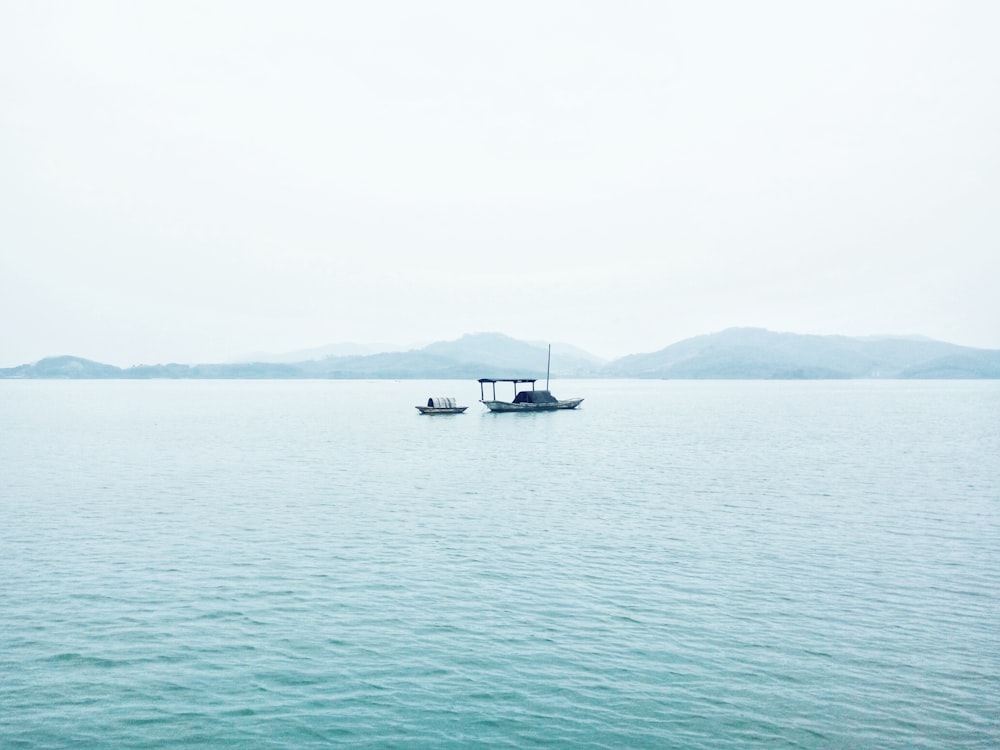 two white boats in middle of sea during daytime