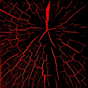 A pattern resembling a cracked surface with red fissures spreading outwards on a black background. The cracks are irregular and create a web-like appearance.