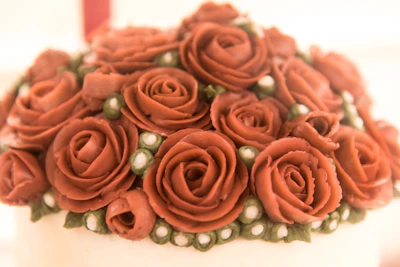 Close-up of detailed cake decoration with delicate flowers and gold touches.
