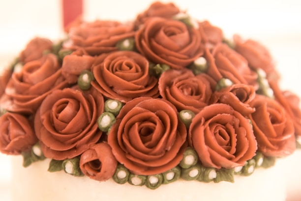 Close-up of a beautifully decorated cake with delicate floral icing in a cozy bakery setting