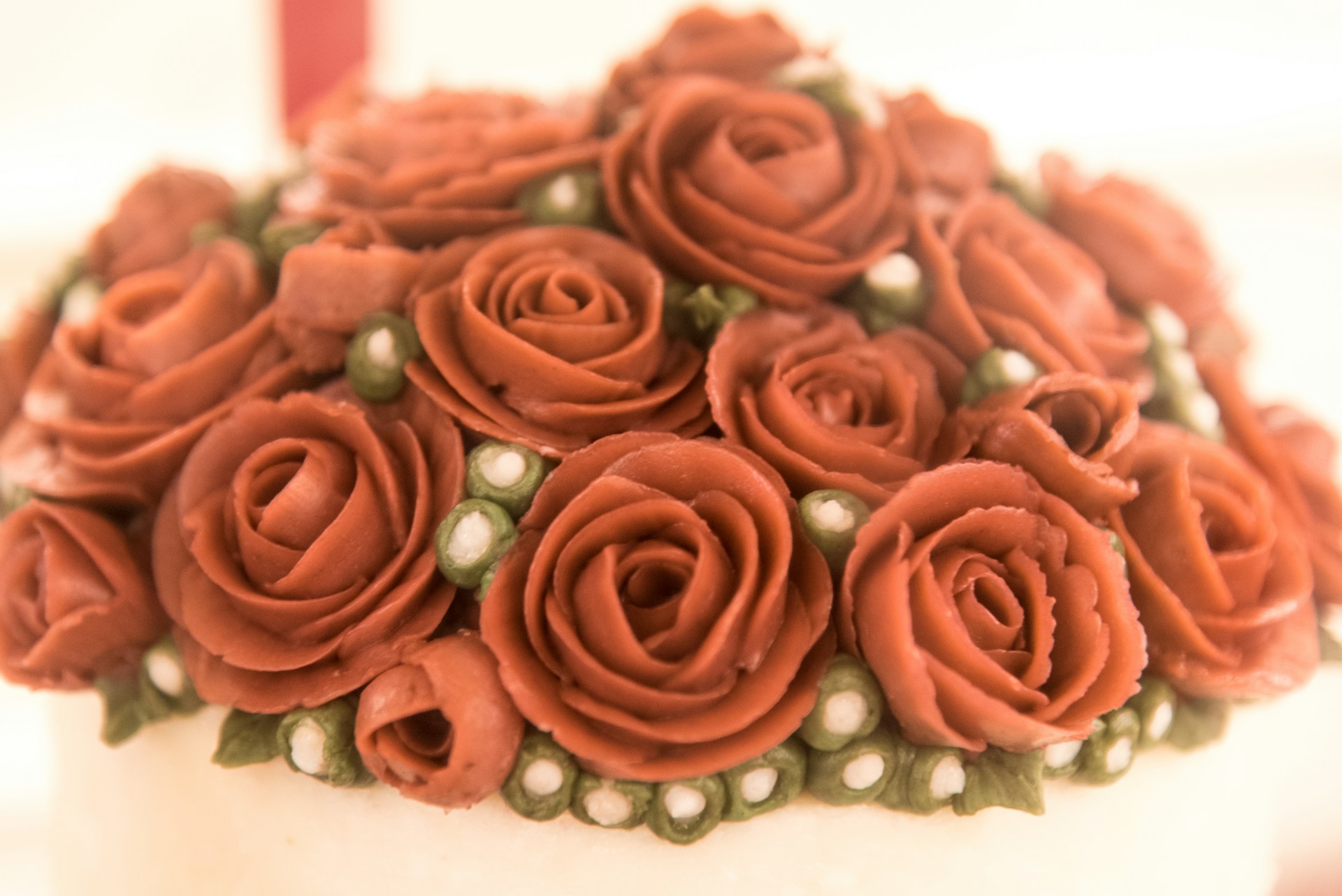 A close-up of a customized cake adorned with fresh flowers and intricate decorations.