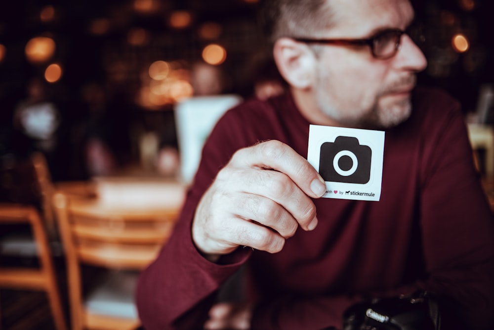 uomo che cammina una carta con l'icona della macchina fotografica