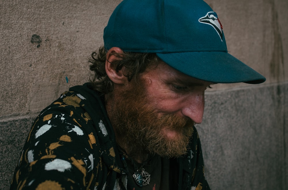 foto de un hombre con gorra de ala curva verde azulado de los Toronto Bluejays