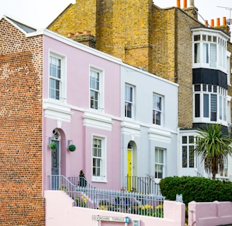 a row of pastel houses on a street corner