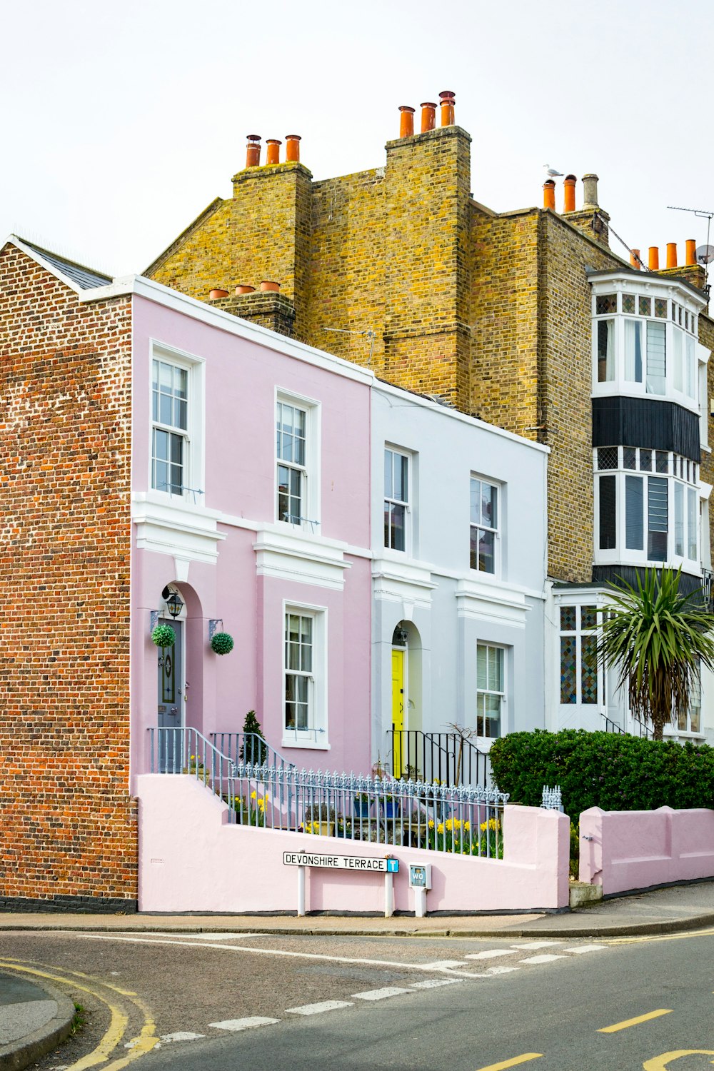 a row of pastel houses on a street corner