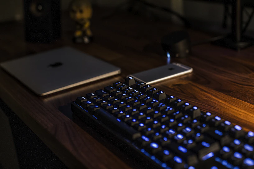 Sleek black and blue laptop setup on a modern office desk with subtle ambient lighting