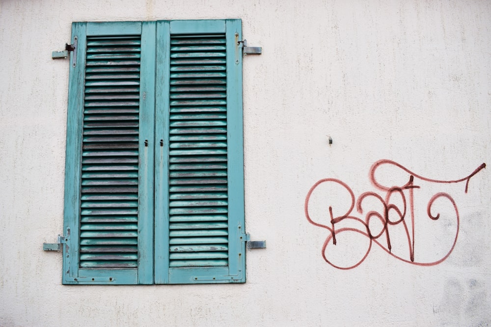 Tagsüber das türkisfarbene Holzfenster geschlossen