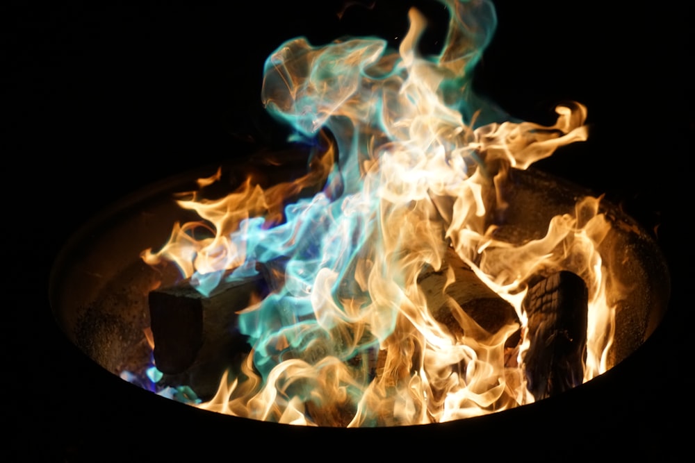 orange and blue flame on pile of wood