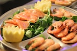 A close-up of a seafood platter featuring shrimp, mussels, and lemon wedges.