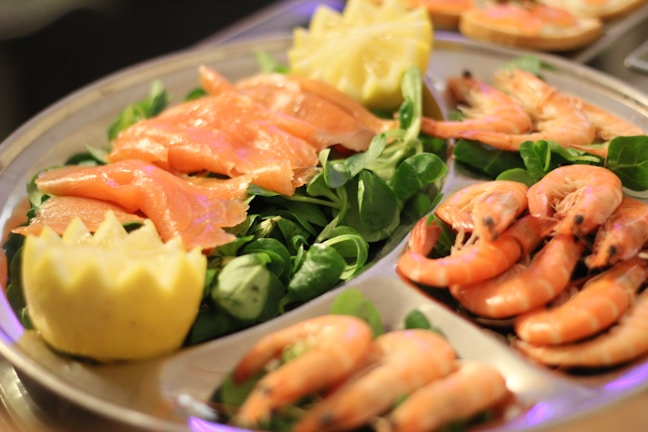 Close-up of a vibrant seafood platter with Gulf shrimp, oysters, and lemon wedges.