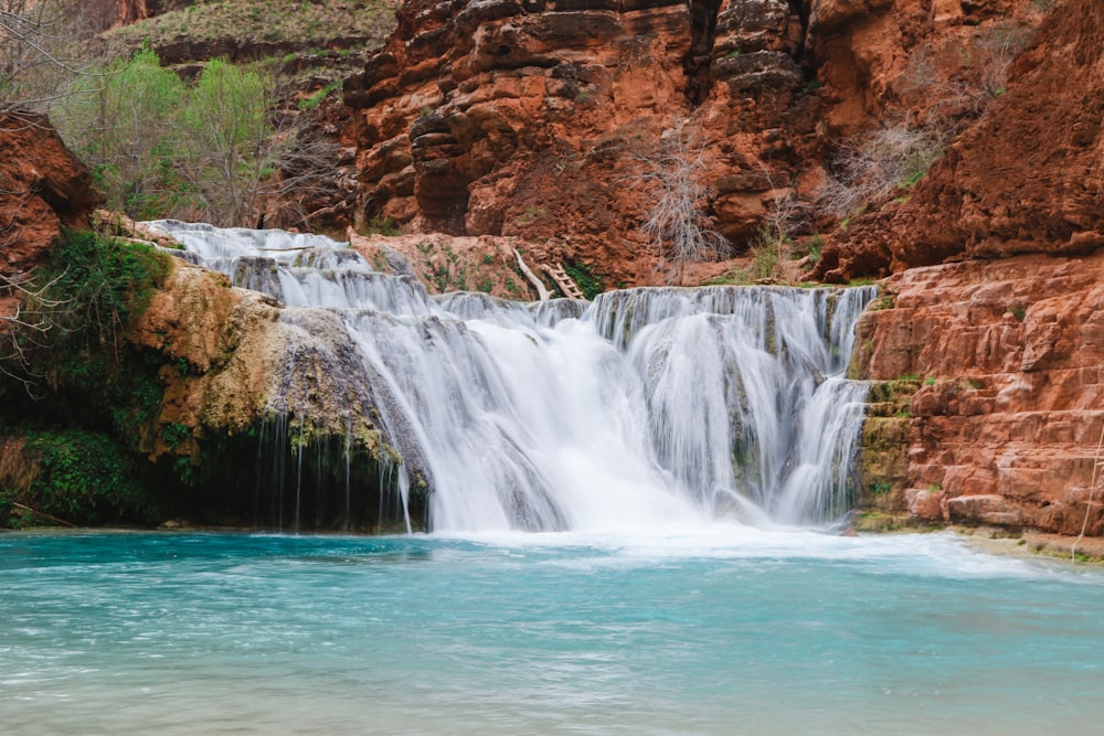 L’eau tombe près de la formation de roches brunes pendant la journée