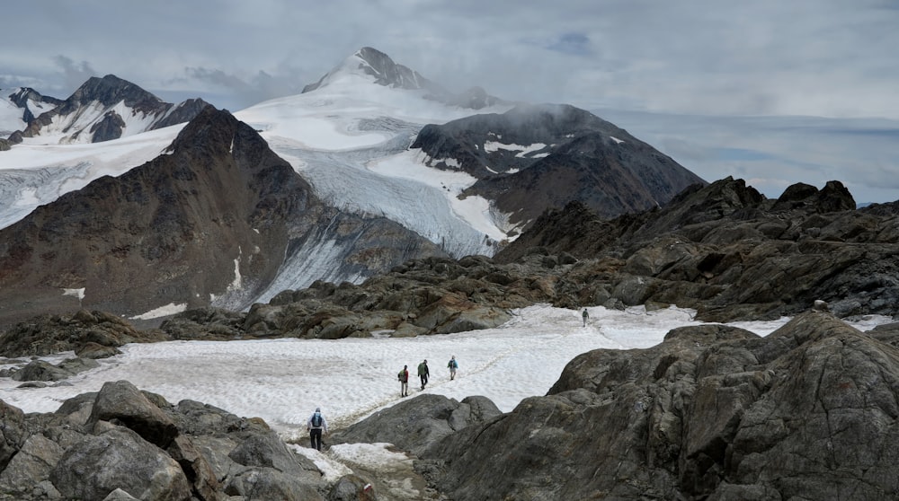 Grupo de pessoas caminhando em montanhas nevadas