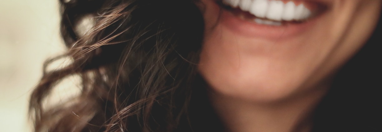 long black haired woman smiling close-up photography