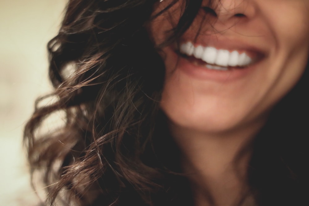 Mujer de pelo negro largo sonriendo fotografía de primer plano