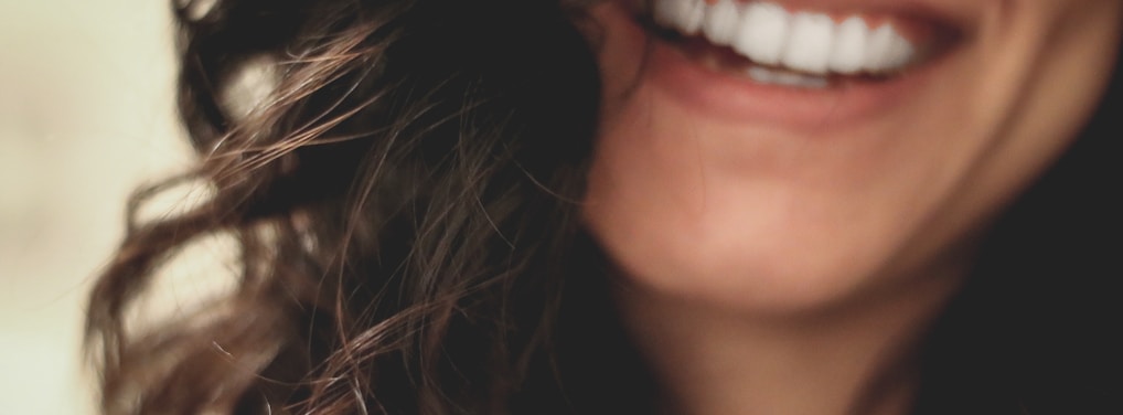 long black haired woman smiling close-up photography