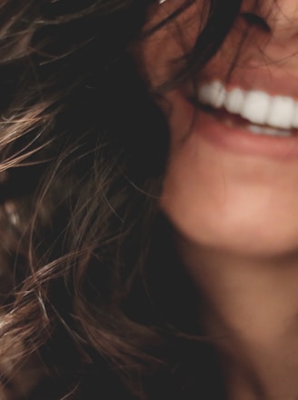 long black haired woman smiling close-up photography