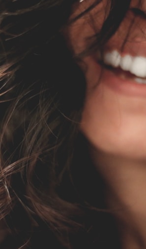 long black haired woman smiling close-up photography