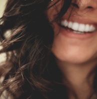 long black haired woman smiling close-up photography