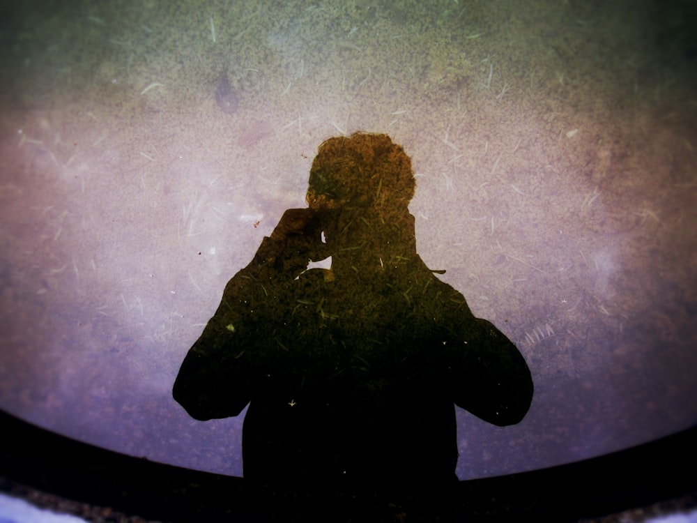 silhouette photography of man holding camera