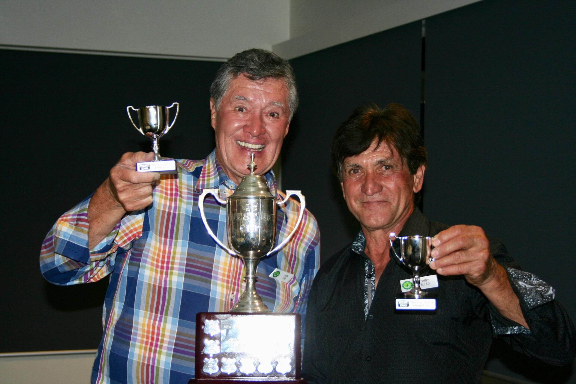 Members of Legado Noble celebrating a tournament victory, holding trophies with proud and satisfied expressions.