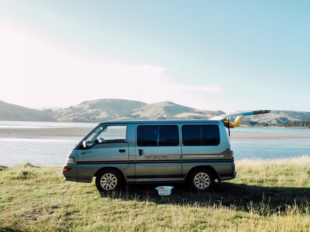 silver van parked on green grass field